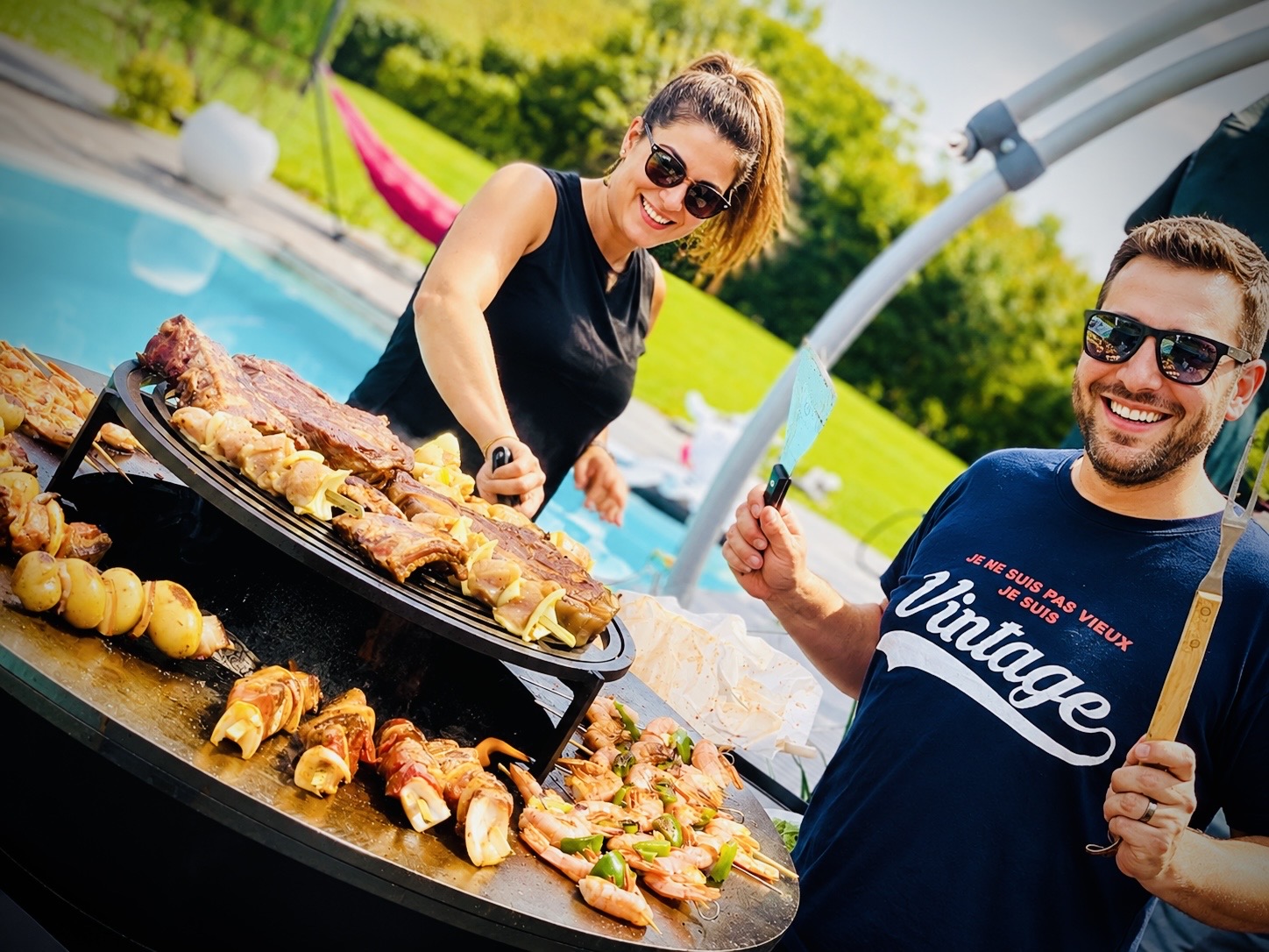 Barbecue Ofyr en extérieur avec des convives préparant des brochettes